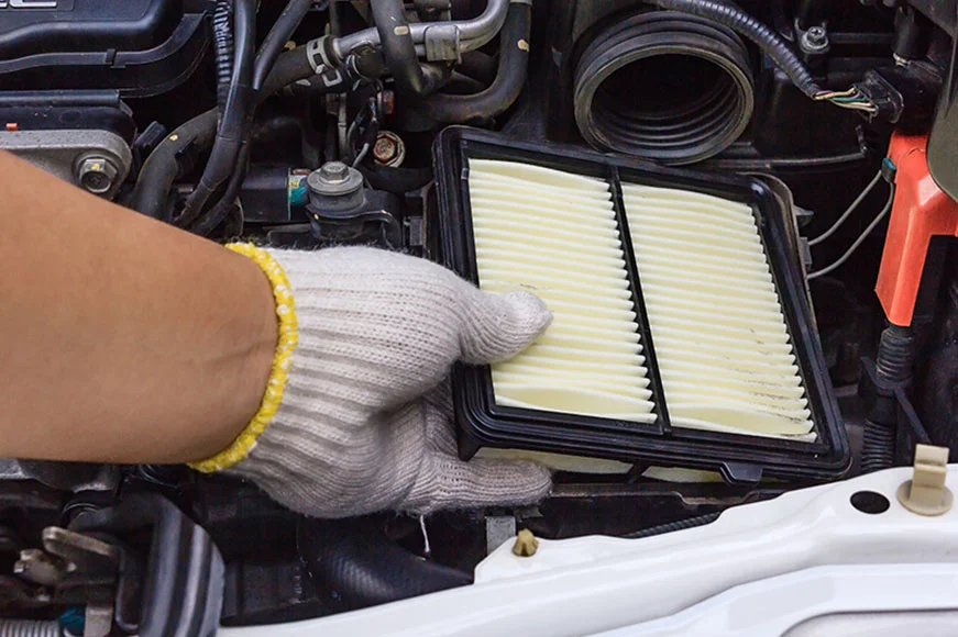 GMC Certified Maintenance professional changes air filter in an SUV engine