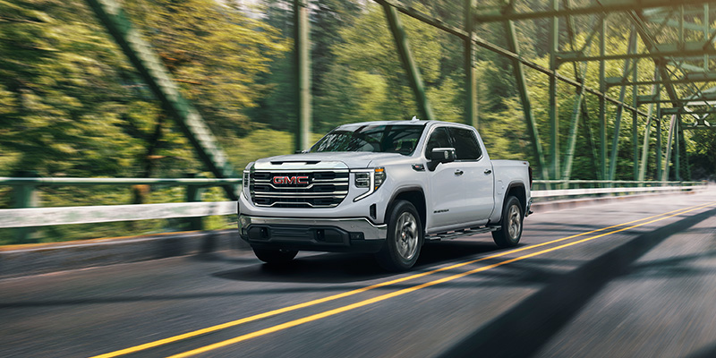 2026 GMC Sierra 1500 driving on countryside bridge