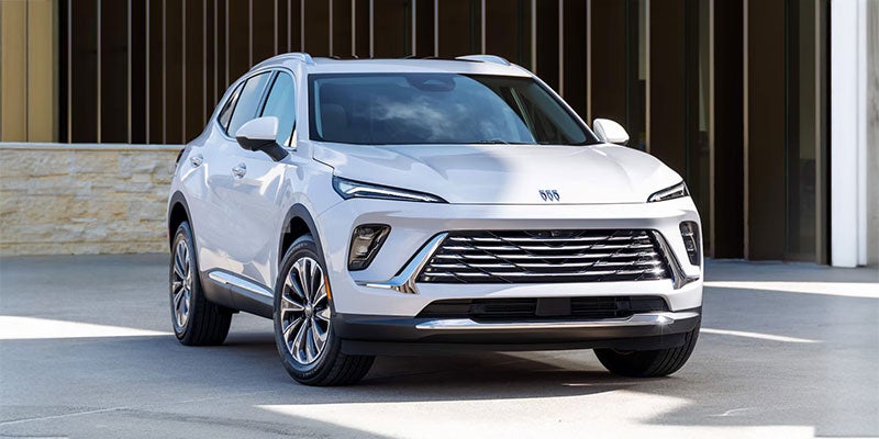 Man and woman standing next to Buick car